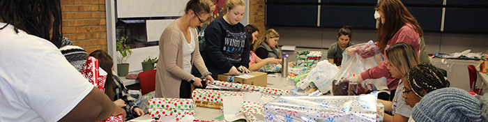 Employees of Civic Engagement wrapping Christmas gifts.