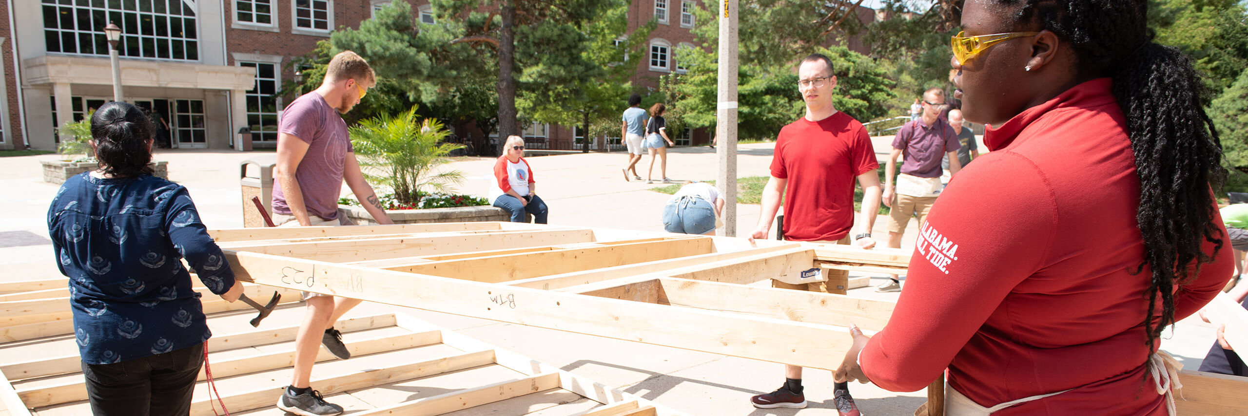 A group of students and volunteers assisting in constructing homes for Habitat for Humanity.